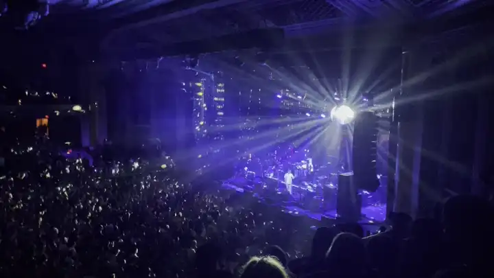Disco Ball spinning in the Masonic Temple Theatre casting light on the audience and stage.