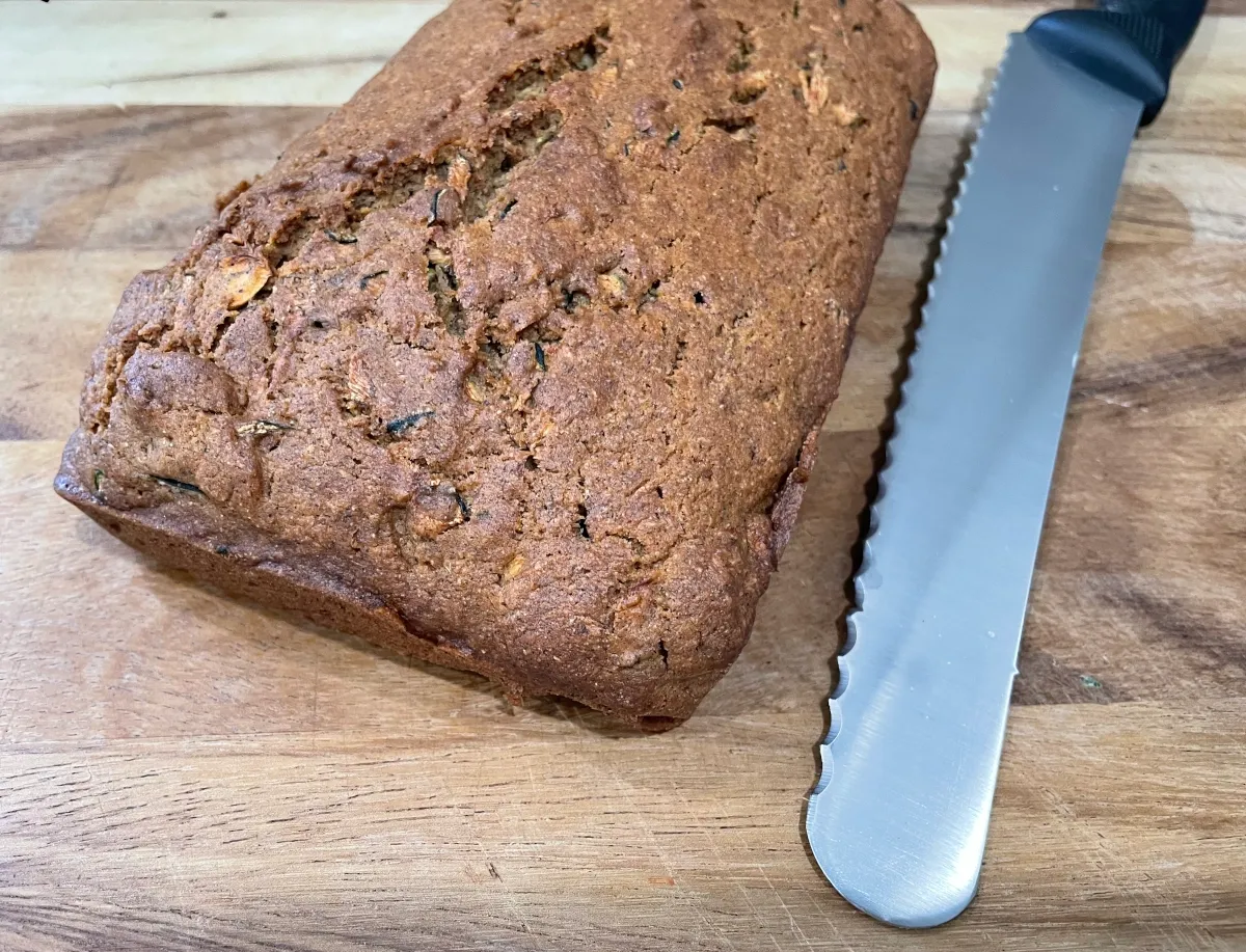 Bread on a wood cutting board with a bread knife.